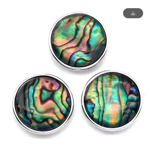 Three snap charms with abalone shell designs in different orientations, each with a metallic silver backing.