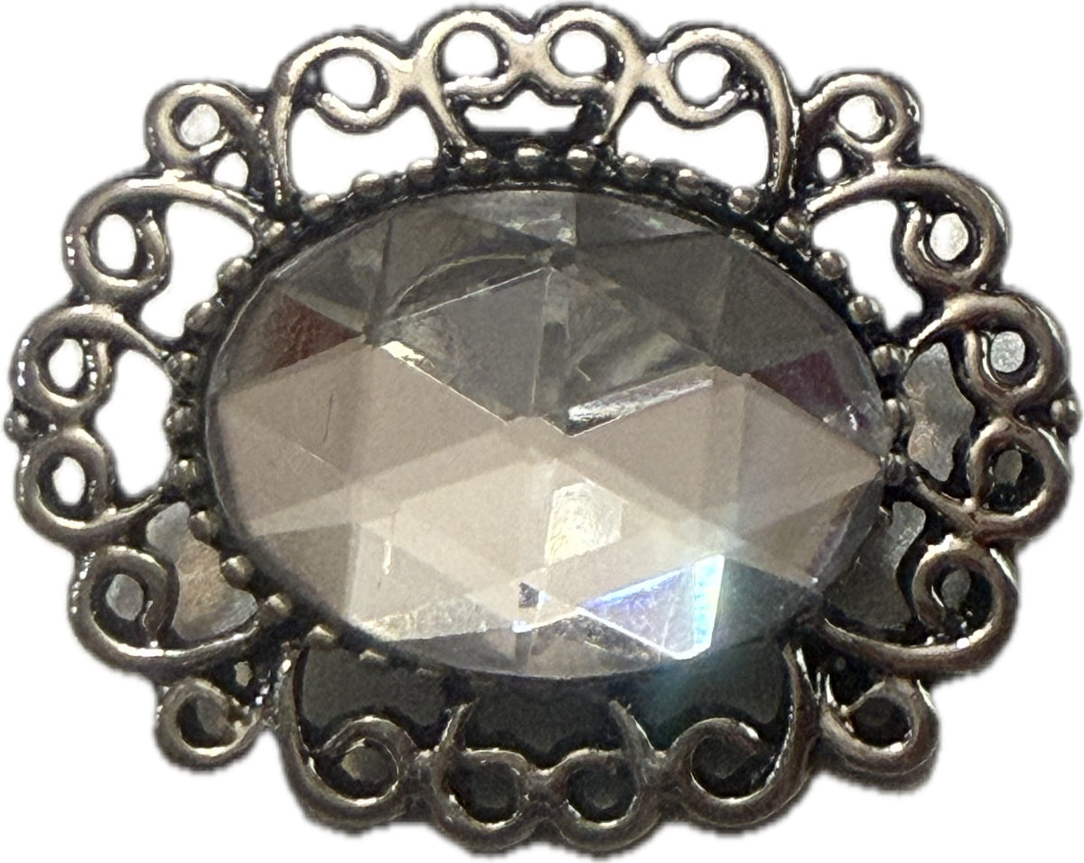 Simple Elegance Jewelry 20mm oval snap charm with a clear faceted rhinestone and intricate silver filigree edge.