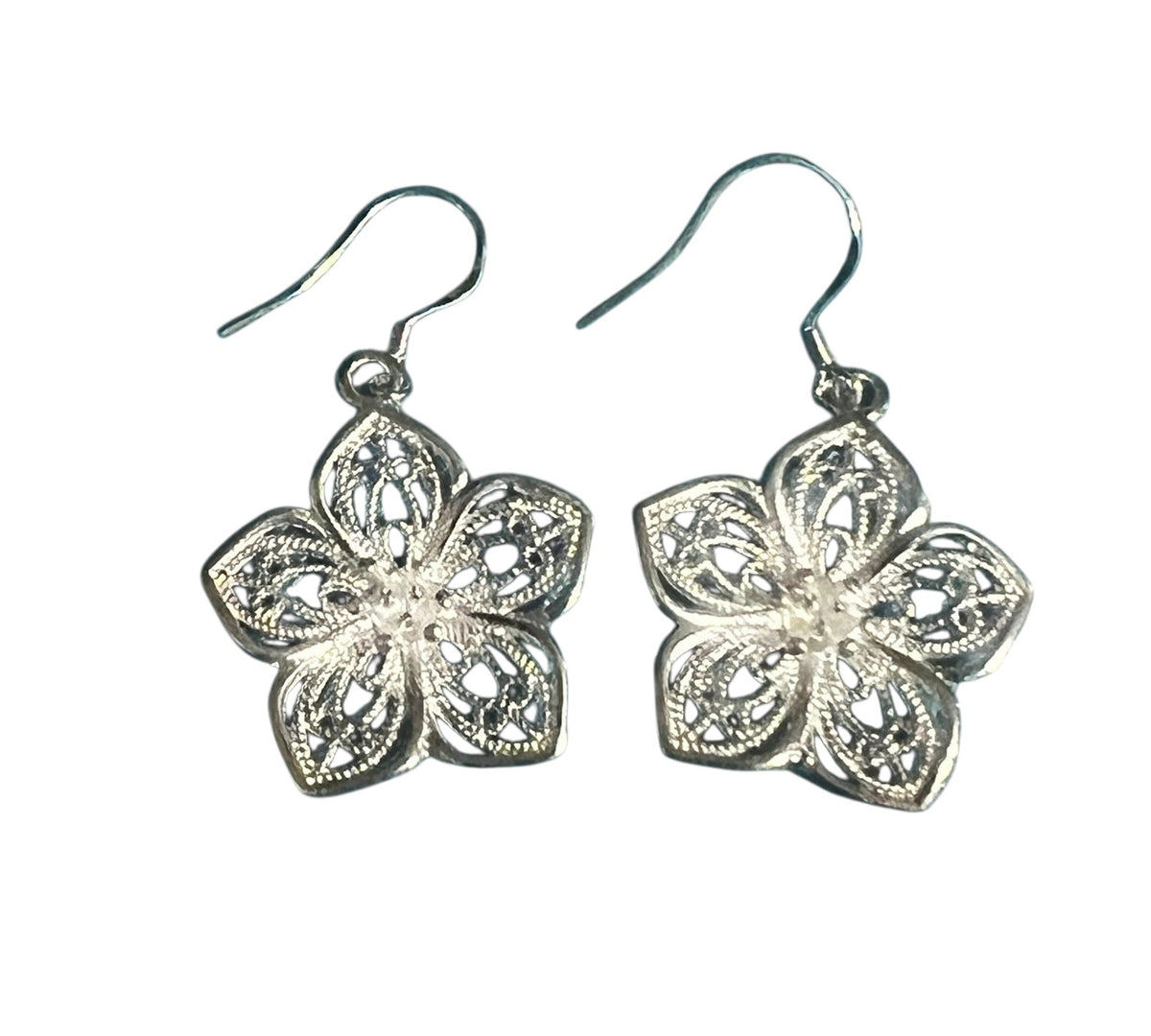 Simple Elegance Jewelry silverplated flower dangle earrings with intricate open cut-out filigree design on blue background