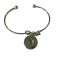 Simple Elegance Jewelry silver bangle bracelet featuring a love knot and a 20mm interchangeable snap charm.